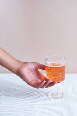 Yaratıcı yaz kokteyli konsepti. Pastel arka planda pembe içkili kadın eli ve cam. Kopyalama alanı olan en küçük bileşim. 