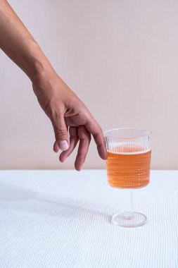 Yaratıcı yaz kokteyli konsepti. Pastel arka planda pembe içkili kadın eli ve cam. Kopyalama alanı olan en küçük bileşim. 