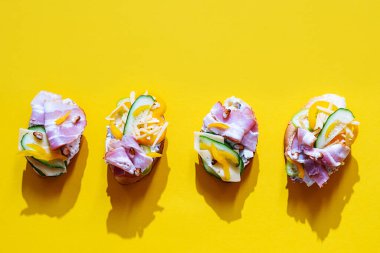 Bright summer still life of healthy, trendy snacks. Various sandwiches with cream cheese, quail eggs, tomatoes, bacon and vegetables. Flat lay in  minimalistic style.