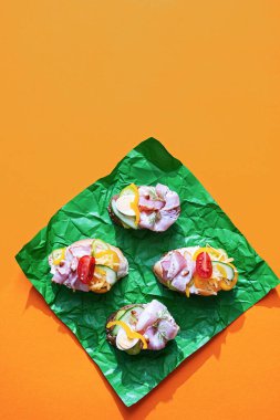 Çeşitli dolgulu açık sandviçler. Krem peynirli Smorrebrod, bıldırcın yumurtası, domates, pastırma ve sebze. Modern, yaz aylarında sağlıklı atıştırmalıklar. Minimalizm tarzında düz yatıyordu.