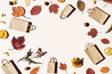 Yaratıcı alışveriş torbaları, renkli sonbahar yaprakları, kurutulmuş çiçekler, meşe palamutları ve kurutulmuş portakal dilimleri..