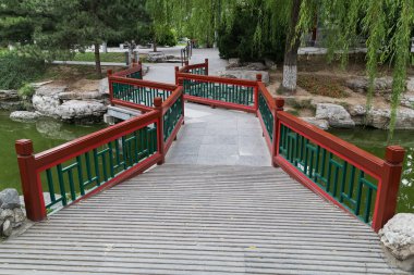Walkway across the river in Old traditional park in Beijing,  China clipart