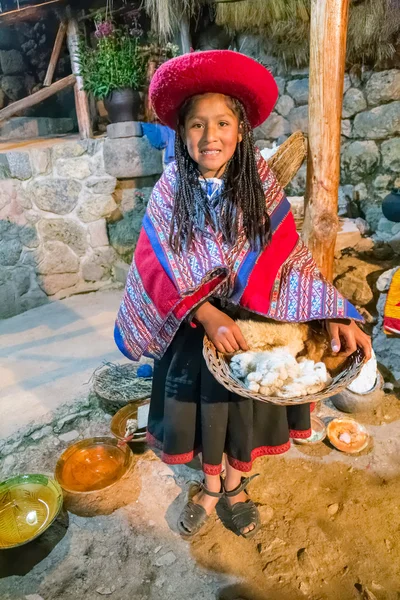 Ollantaytambo, Perú - circa junio 2015: Chica con ropa tradicional peruana sostiene una canasta con lana de Alpaca y Llama cerca de Cusco, Perú — Foto de Stock