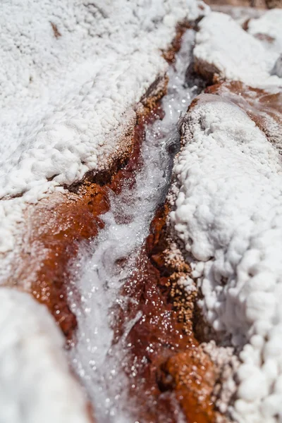 Agua que corre entre depósitos de cristales de sal en estanques de evaporación en Maras, Perú — Foto de Stock