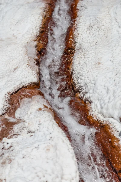 Agua que corre entre depósitos de cristales de sal en estanques de evaporación en Maras, Perú — Foto de Stock