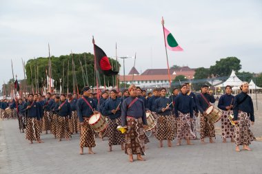 YOGYAKARTA, INDONESIA - CIRCA SEPTEMBER 2015: Ceremonial Sultan Guards in sarongs march in formation in front of Sultan Palace (Keraton), Yogyakarta,  Indonesia clipart