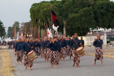 YOGYAKARTA, INDONESIA - CIRCA SEPTEMBER 2015: Ceremonial Sultan Guards in sarongs march in formation in front of Sultan Palace (Keraton), Yogyakarta,  Indonesia clipart