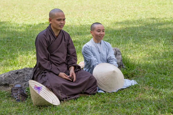 HUE, VIETNAM - CIRCA AGOSTO 2015: monges budistas sentam-se no quintal dos templos na grama — Fotografia de Stock