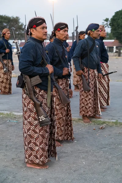 YOGYAKARTA, INDONÉSIA - CIRCA SETEMBRO 2015: Guardas de Sultão Cerimonial em sarongues com espingardas em frente ao Palácio do Sultão (Keraton), Yogyakarta, Indonésia — Fotografia de Stock
