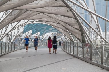 Singapore, Singapore - circa September 2015: People walking and running on Helix Bridge in  Singapore
