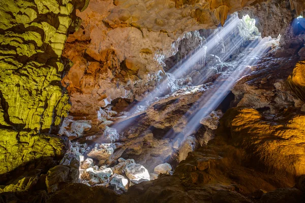 Raios de sol vêm através do buraco do teto em Dau Go caverna em Halong Bay — Fotografia de Stock