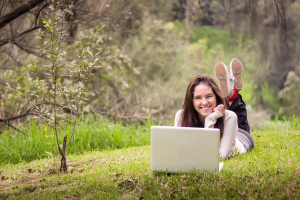 Νεαρή όμορφη γυναίκα χρησιμοποιώντας ένα φορητό υπολογιστή στο πάρκο — Φωτογραφία Αρχείου