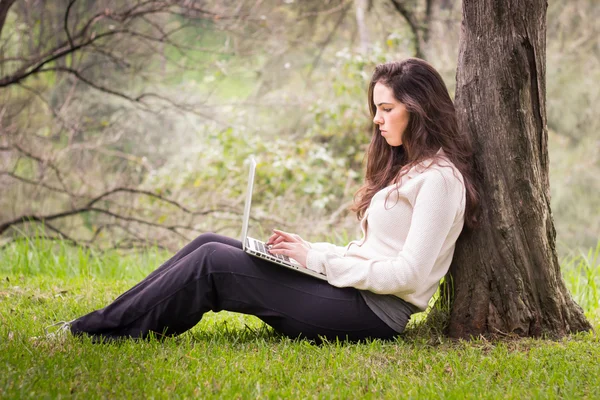 Wanita cantik muda menggunakan laptop komputer di taman — Stok Foto