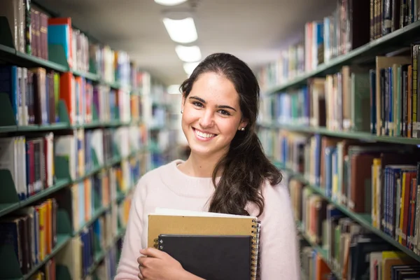 Dans la bibliothèque - jolie étudiante avec des livres qui travaillent en une heure — Photo