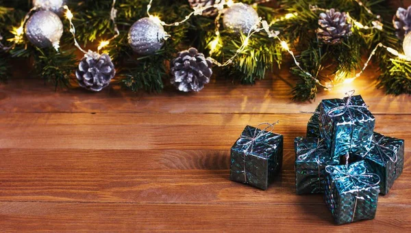 Weihnachtsgeschenke Und Weihnachtsbaum Mit Lichterkranz Auf Einem Holztisch — Stockfoto