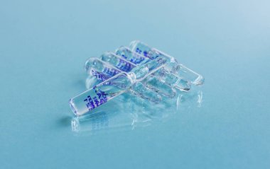 Ampulün mavi arka planında enjeksiyon için ampuller 