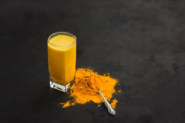 Golden Milk, Turmeric Latte, Golden Latte on dark background, Spices of India healthy food