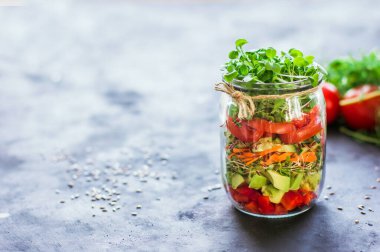 Açık kavanozda sebze salatası domates, avokado, biber, salatalık, mikro yeşiller sağlıklı yiyecekler, diyet, temiz yiyecekler ve vejetaryen konsepti.