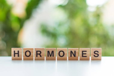 hormonlar mesaj işareti ahşap bir tablo üzerinde yeşil yaprakların arka plan karşı yumuşak odaklı