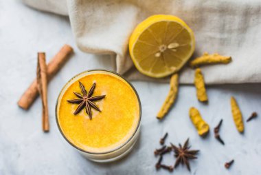 Sağlıklı Ayurvedic içecek ile altın badem sütü ya da hafif arka planda zerdeçal tozlu zerdeçal latte. Vejetaryenler için baharatlı Asya doğal detoks içeceği