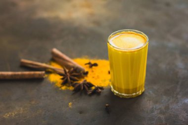 Sağlıklı detoks zerdeçal latte. Safranlı altın süt, baharatlar ve koyu arkaplanda limon. Sağlıklı Ayurvedic içeceği. Bağışıklık sistemini güçlendiriyorum. Antioksidan ve süper yiyecek.