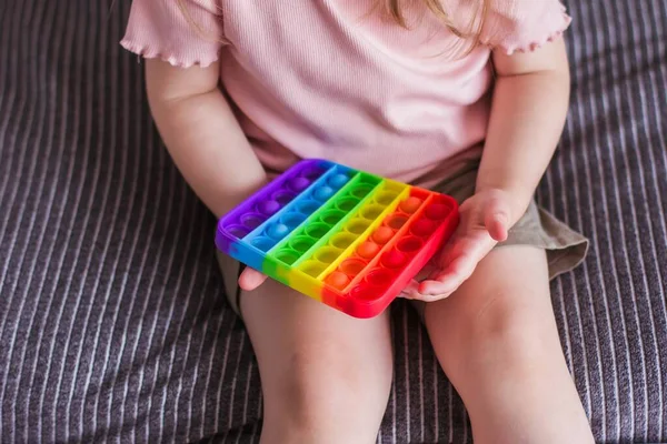 Une Petite Fille Assoit Tient Jouet Dans Ses Mains Arc Photo De Stock