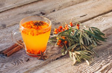 Sıcak vitamin denizi karabatak çayı bir fincana, eski ahşap bir masanın üzerinde duruyor. Rahatlama ve bitkisel ilaçlar, soğuk algınlığı önleyici içecek, grip mevsimi