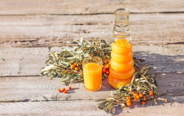 Bir sürahide deniz karabatağı suyu ve eski bir ahşap arka planda bir bardak. Rahatlama ve bitkisel ilaçlar, soğuk algınlığı önleyici içecek, grip mevsimi