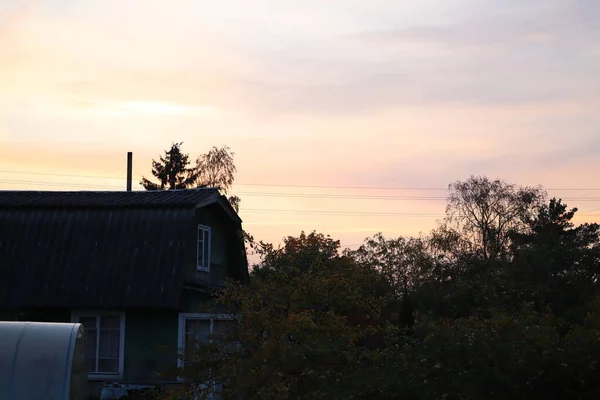 田舎でしか見られない景色村家の屋根からの美しい夕日 — ストック写真