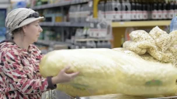 Eine Frau in einem Geschäft kauft eine große Tüte Cornflakes. — Stockvideo