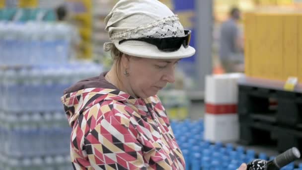The lady chooses the wine at the grocery store. — Stock Video