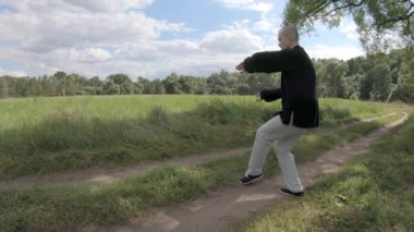 Wushu, adam düzgün hareket ediyor sonra da eliyle keskin bir şekilde vuruyor.