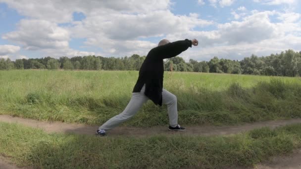 De mens vecht tegen een denkbeeldige tegenstander in de stijl van Wushu vuist van de grote limiet — Stockvideo