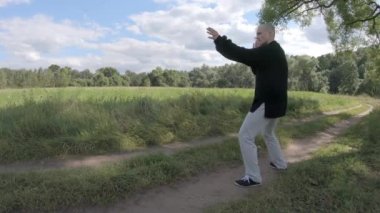 Usta, bir söğüt ağacının gölgesinde hayali bir düşmanla savaşıyor.