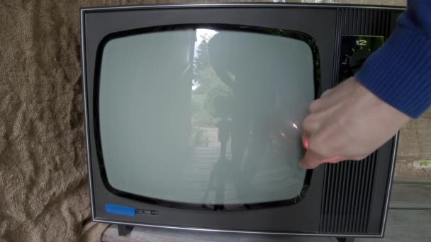 L'homme dirige une télé à doigt clignotant. Interférence analogique à l'écran — Video