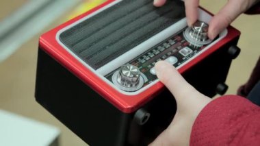 Kadın elleri eski bir retro alıcıyla FM dalgasını yakalıyor.