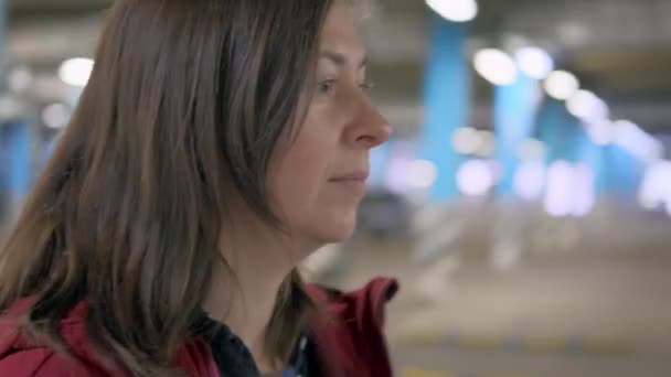 Подземная парковка женщина идет и крутит ключи от машины — стоковое видео