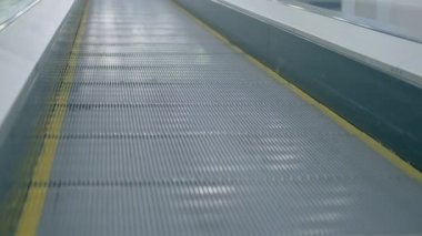 Mağazadaki demir yürüyen merdiven yavaşça yükseliyor.