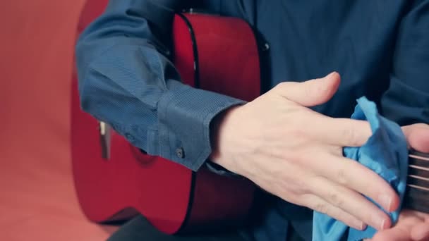Férfi kéz vigyázni akusztikus gitár törlőkendő szerszám a por — Stock videók