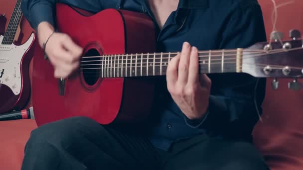 Händer på en europeisk man spelar en akustisk gitarr — Stockvideo