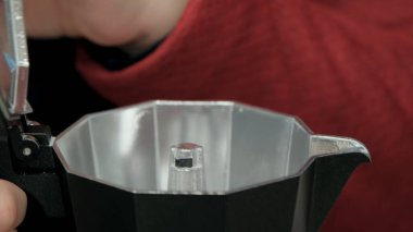 Kız doğada kahve yapmak için gayzer kahve makinesine benziyor.