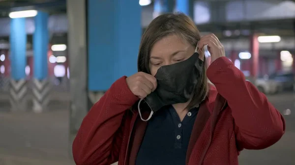 Caucasian woman puts on a mask against virus — Stock Photo, Image