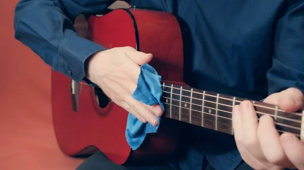 Les mains des hommes prennent soin de l'outil d'essuyage de guitare acoustique de la poussière — Photo