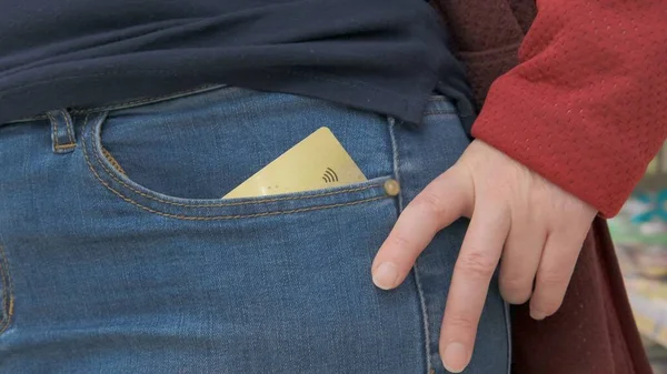 Банковская карта с бесконтактным значком платежа в женском кармане — стоковое фото