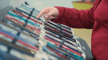 Kadın bir dükkanda bir telefon seçiyor.