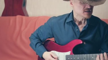 Sakallı adam gitar çalıyor ve heavy metal söylüyor.