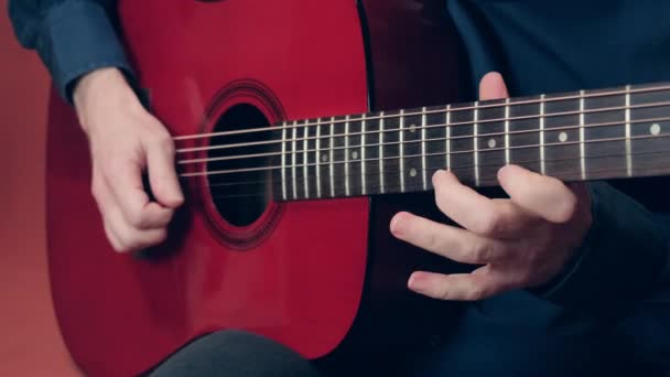 男人试图用耳朵捡起一支曲子，在吉他上弹奏 — 图库视频影像