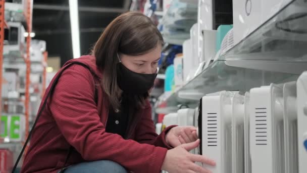 Köpa en termisk konvektor i en butik under en pandemi — Stockvideo