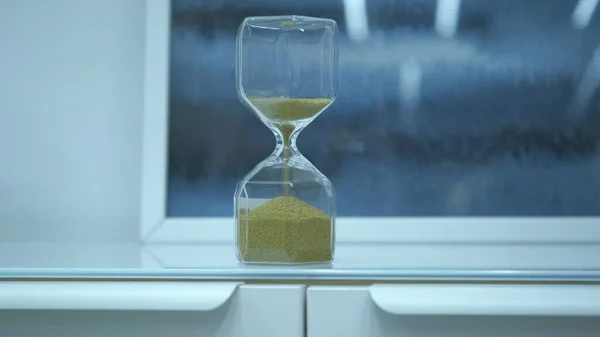 Sanduhr aus Glas vorhanden. Die letzten Körnchen Zeit laufen davon — Stockfoto