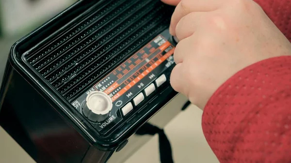 Kadınların elleri bükülmüş, eski, eski FM radyo.
